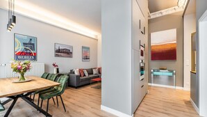A modern living space with a dining area, sofa, and artwork on the walls. - Luxurious 3-Bedroom Designer Apartment (Berlin)