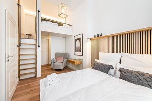 Una camera da letto con un letto a castello, una sedia, un comodino e un quadro appeso al muro.