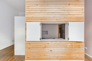 Ein Zimmer mit Holzvertäfelung, einem Bett und einer weißen Tür.