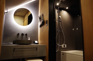 A modern bathroom with a round mirror, a sink, a handheld showerhead, and a bathtub. - TOVILLA STAY Niigata Honcho (Niigata-shi, Chuo-ku)