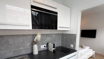 Una cocina moderna con microondas integrado, un lavamanos y una encimera.