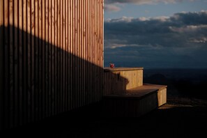 Una estructura de madera con una plataforma y un objeto rojo pequeño en la parte superior.