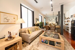 Ein Wohnzimmer mit einer Couch, einem Couchtisch und einem Essbereich mit Stühlen und einem Tisch.