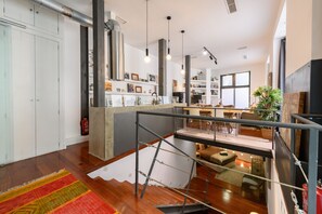 Ein modernes Interieur mit Treppe, Holzboden und Küchenbereich mit Essbereich.