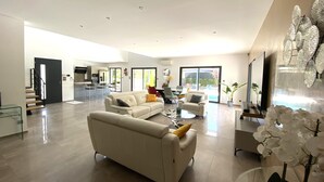 A spacious living area with a sofa, coffee table, and decorative plants. - "Le BEL AIR" House with pool, AC, and Wi-Fi—Near the ocean (La Ciotat)