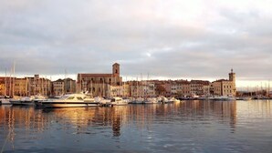 A marina with multiple boats docked, a prominent tower, and a row of buildings along the waterfront. - "Le BEL AIR" House with pool, AC, and Wi-Fi—Near the ocean (La Ciotat)