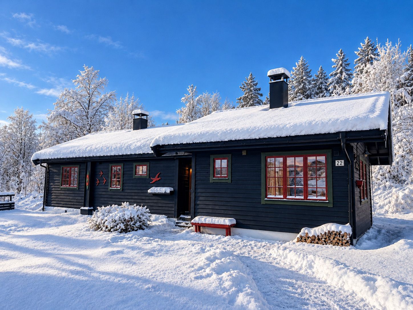 Een besneeuwde hut met een schoorsteen, een bord met het nummer '22' en een bank ervoor.