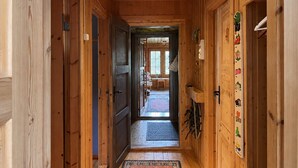 A wooden hallway with a door leading to a room with a view.