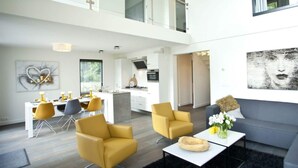 A modern interior with a dining area, sofa, and a kitchen. - Cube Magnifique 8 (Nijkerk)