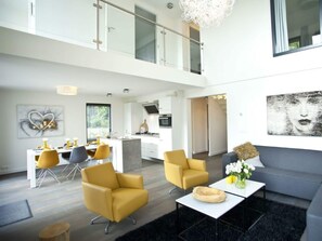 Ein modernes Interieur mit Essbereich, einer Couch und einer Küche.