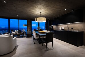 Una cocina moderna con una isla grande, un comedor con vistas y una zona de estar acogedora.