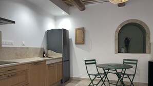 Eine Küche mit Essbereich, Holzausstattung, einem Kühlschrank und einem Tisch mit Stühlen.