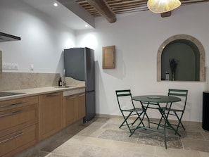 Eine Küche mit Essbereich, Holzausstattung, einem Kühlschrank und einem Tisch mit Stühlen.