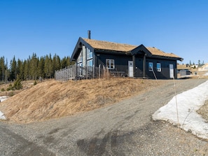 A house with a sloped roof, a chimney, and a fenced yard.