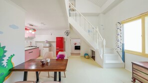 A kitchen with a red fridge, a white staircase, and a dining area with a wooden table. - Gapyeong Darin Pension (Gapyeong)