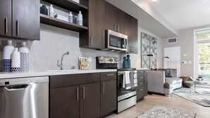 A modern kitchen with dark wood cabinets, stainless steel appliances, and a built-in microwave. - Charming 1-bedroom castle in beautiful Oakland with AC and gym (Oakland)