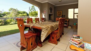 A wooden dining table with chairs, a fireplace, and a view of the outdoors.