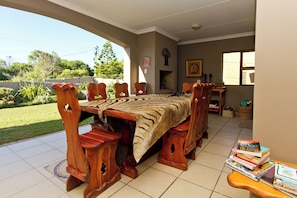 Una mesa de comedor de madera con sillas, una chimenea y vistas al exterior.
