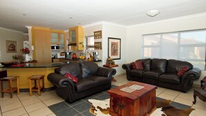 A living room with two leather sofas, a wooden coffee table, and a cowhide rug.