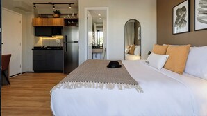 A modern hotel room with a large bed, a kitchen area, and a dining table. - Charlie Murat Vila Madalena (São Paulo)