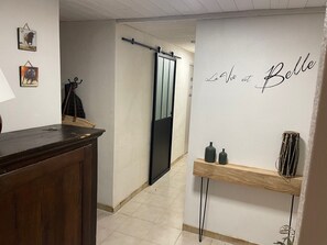 Ein modernes Interieur mit einem Holztisch, einer Schiebetür und einer Wand mit einem dekorativen Schild.