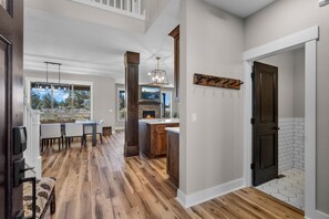 A spacious kitchen with a fireplace, wooden flooring, and a dining area with a view. - Brasada Ranchview Hot Tub | Fire Pit | Bunk Room (Powell Butte)