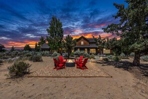 A house with a fire pit and red chairs in a desert setting. - Brasada Ranchview Hot Tub | Fire Pit | Bunk Room (Powell Butte)