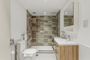 Ein modernes Badezimmer mit Dusche, Toilette und Waschtisch.