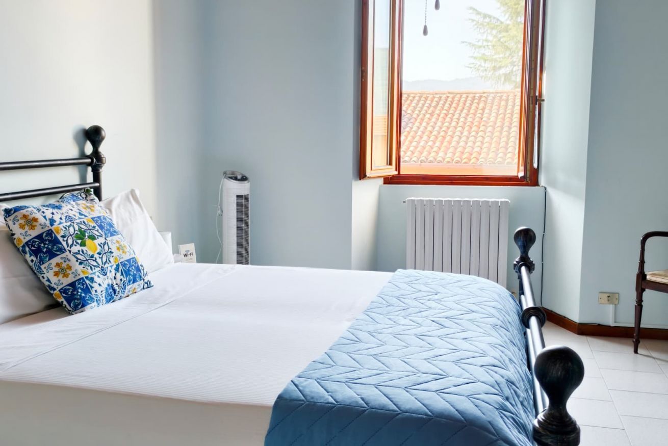 Une chambre à coucher avec un lit, une fenêtre, un radiateur et une chaise.
