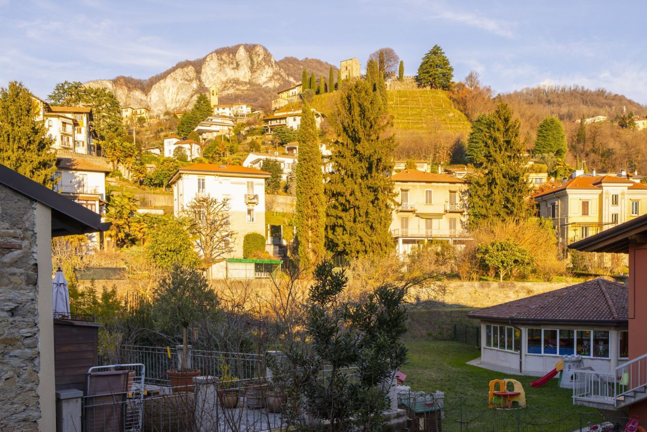 Ein Wohngebiet mit Häusern, einem Spielplatz und einem Berg im Hintergrund.
