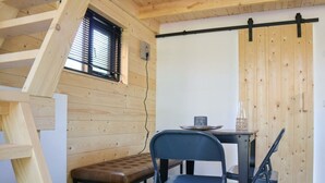 A room with a loft bed, a bench, a table with chairs, and a sliding door. - Holiday Home in Arnhem With Terrace (Arnhem)