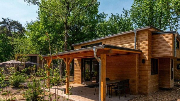 A modern wooden house with a covered patio, a dining area, and a garden. - Holiday Home in Arnhem With Terrace (Arnhem)