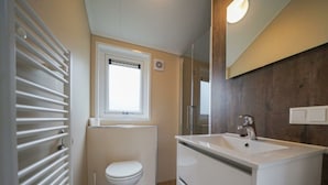 A bathroom with a toilet, a sink, a window, and a radiator. - Holiday Home in Belfeld With Terrace (Belfeld)
