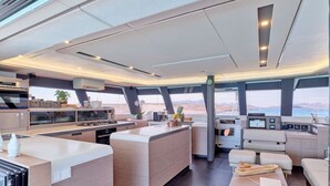Ein modernes Yacht-Interieur mit Küche, Essbereich und Sitzgelegenheiten.