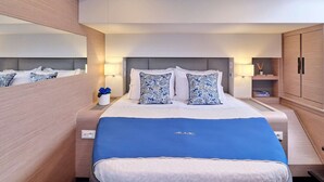 Ein modernes Hotelzimmer mit einem großen Bett, Nachttischen, einem Spiegel und einem Kleiderschrank.