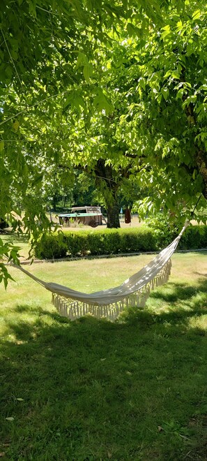 A hammock in a grassy area with a tree overhead. - Bungalow "À l'Orée des Bois" with Shared Pool, Wi-Fi, and Air Conditioning (Monfaucon)