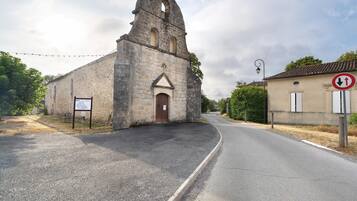 Une église dotée d’un clocher, d’une enseigne et d’une route sur laquelle est placé un panneau indiquant l’interdiction d’accès.