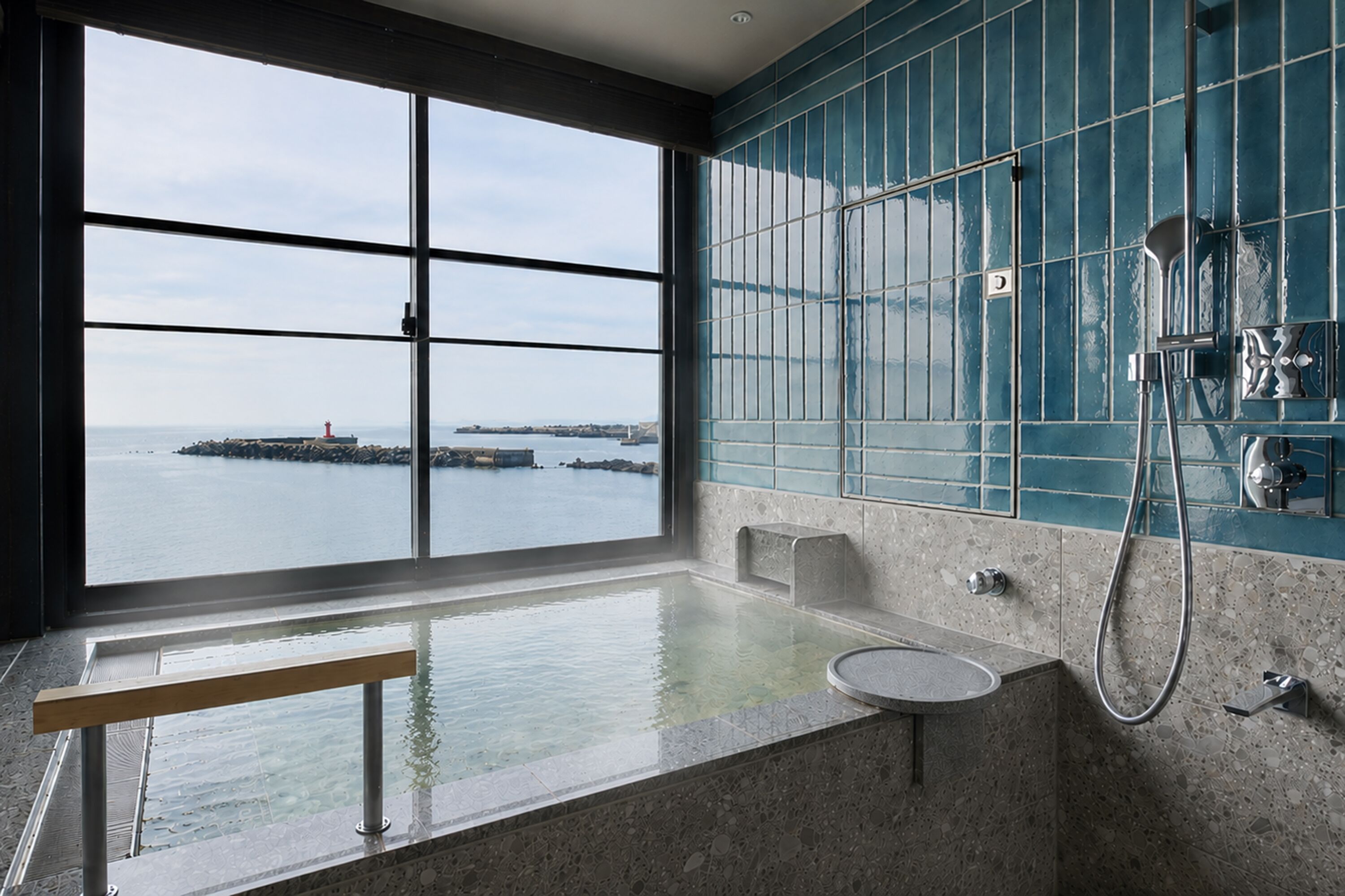 Un baño con un ventanal grande, una bañera y una zona de ducha.