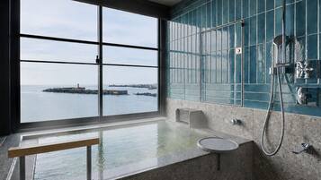 Un baño con un ventanal grande, una bañera y una zona de ducha.