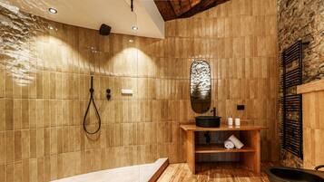 A bathroom with a wooden vanity, a mirror, a shower, and a bathtub.