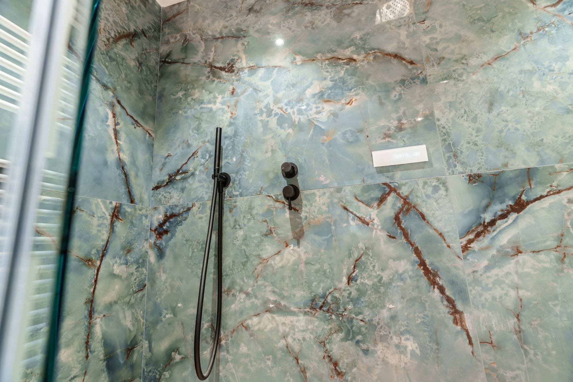 Une salle de bain équipée d’une douche, d’un pommeau de douche amovible et d’un robinet de commande.