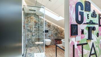 Ein modernes Badezimmer mit Glasabtrennung, Dusche und Waschbecken.