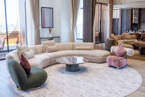 Ein modernes Wohnzimmer mit einem Ecksofa, einem runden Couchtisch und einem einzigartigen Sessel.