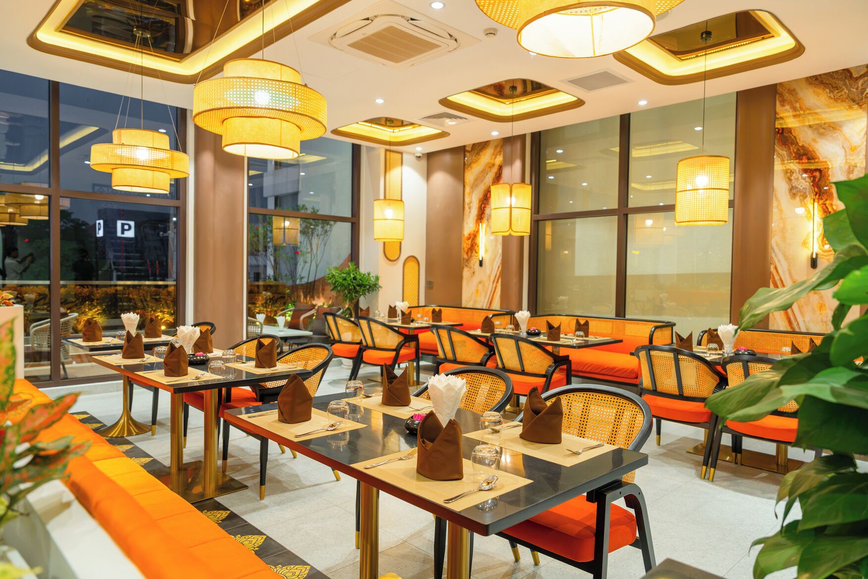 A restaurant with multiple tables, chairs, and hanging lamps.