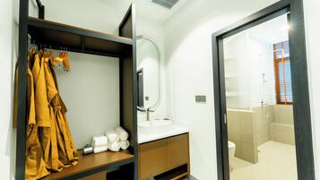 Ein modernes Badezimmer mit integriertem Waschbecken, einem Spiegel und einer begehbaren Dusche.