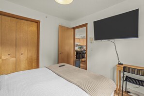 Ein Schlafzimmer mit einem Bett, einem Schreibtisch und einem Fernseher.