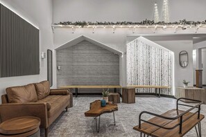 A modern interior with a sofa, a wooden bench, and a coffee table. - Quaint Canmore Basecamp | Views (Canmore)