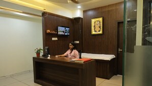 A reception desk with a television, a nameplate, and a potted plant. - Charming 9-bedroom hotel with AC in Indore
Fully Air Conditioned Budget Friendly (Indore)