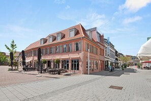 A building with a red-tiled roof, large windows, and outdoor seating. - LiT LiVING Grünstadt (Grünstadt)