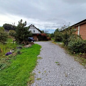Un camí de grava que condueix a una casa, amb un cotxe aparcat a prop.